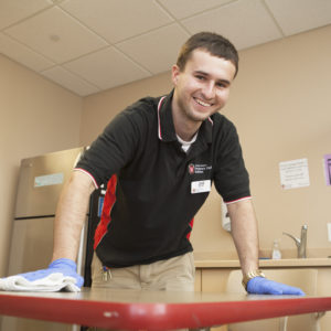 Jake Wears cleans a table in a shared kitchen in Smith Hall.