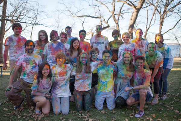 ILS members pose covered in multicolor powder at their Holi Festival