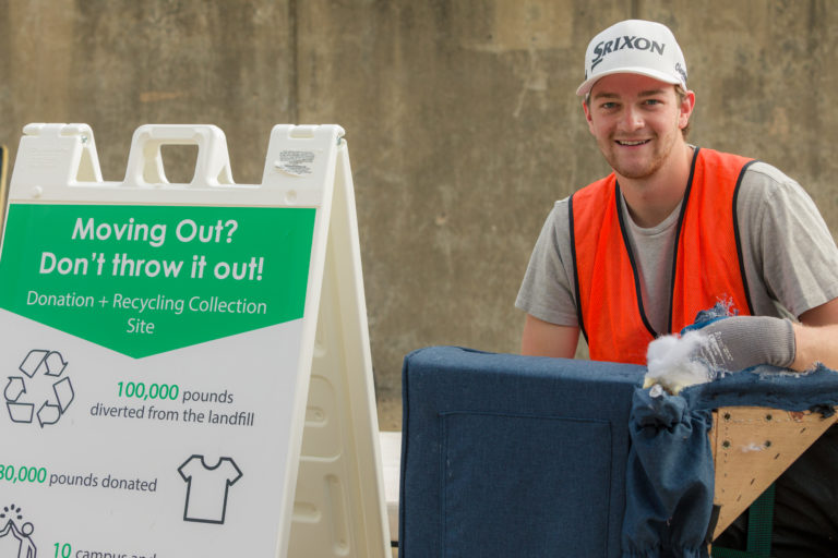 A student helps recycle unwanted belongings at Sustainability Move-out