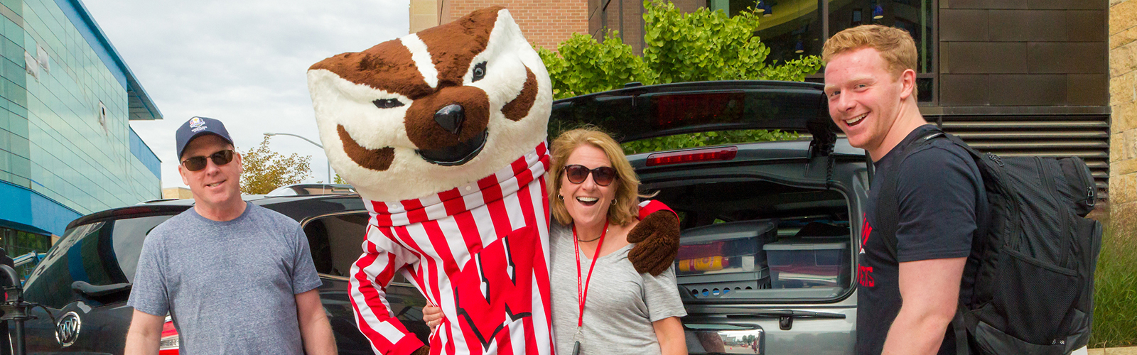 A student and his parents with Bucky Badger at move-in