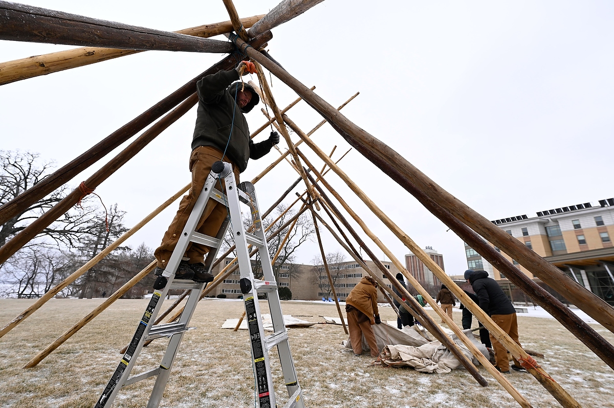Folks work to assemble the indigenous lodge outside of Dejope Residence Hall