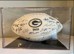 A football signed by the 2021 Green Bay Packers team in a display case
