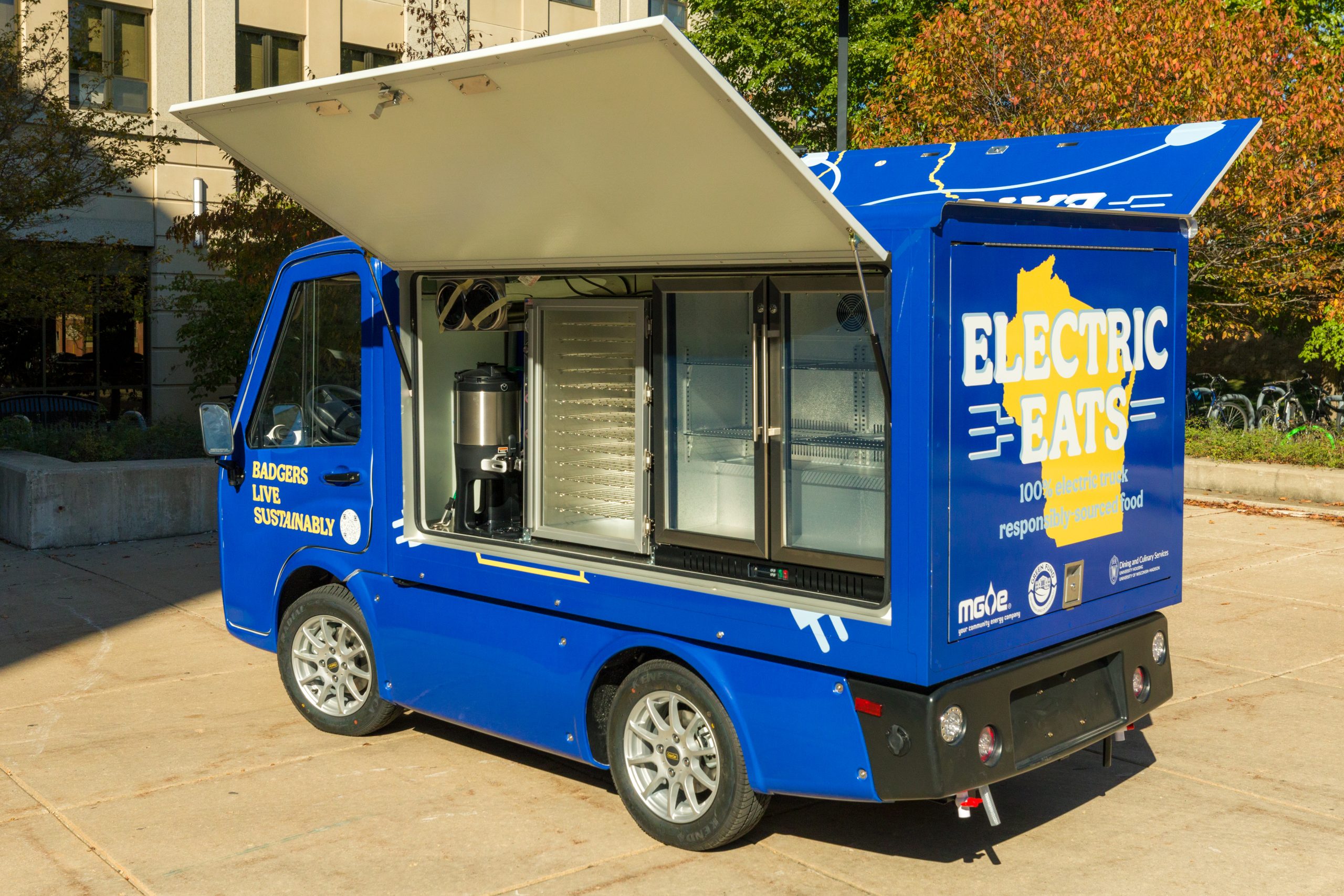 Electric Eats food truck with side panels open showing internal coolers