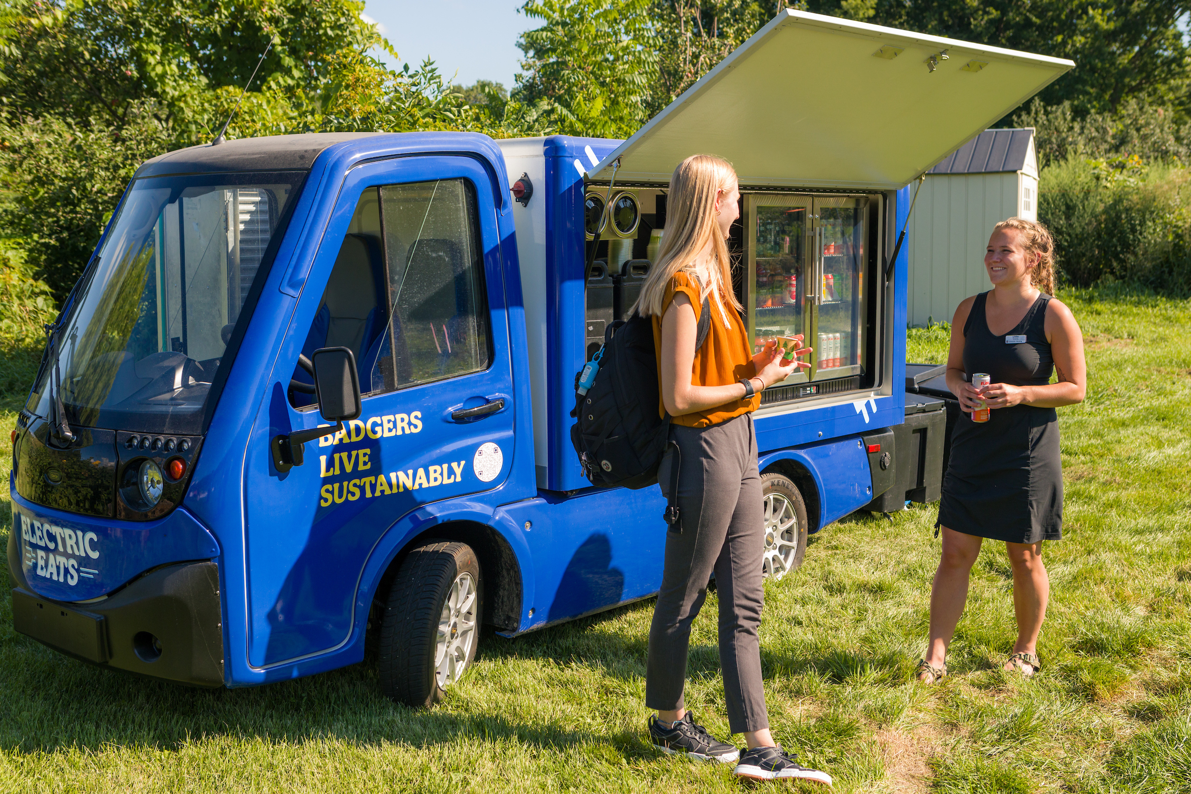 Two students chatting in front of the Electric Eats food truck