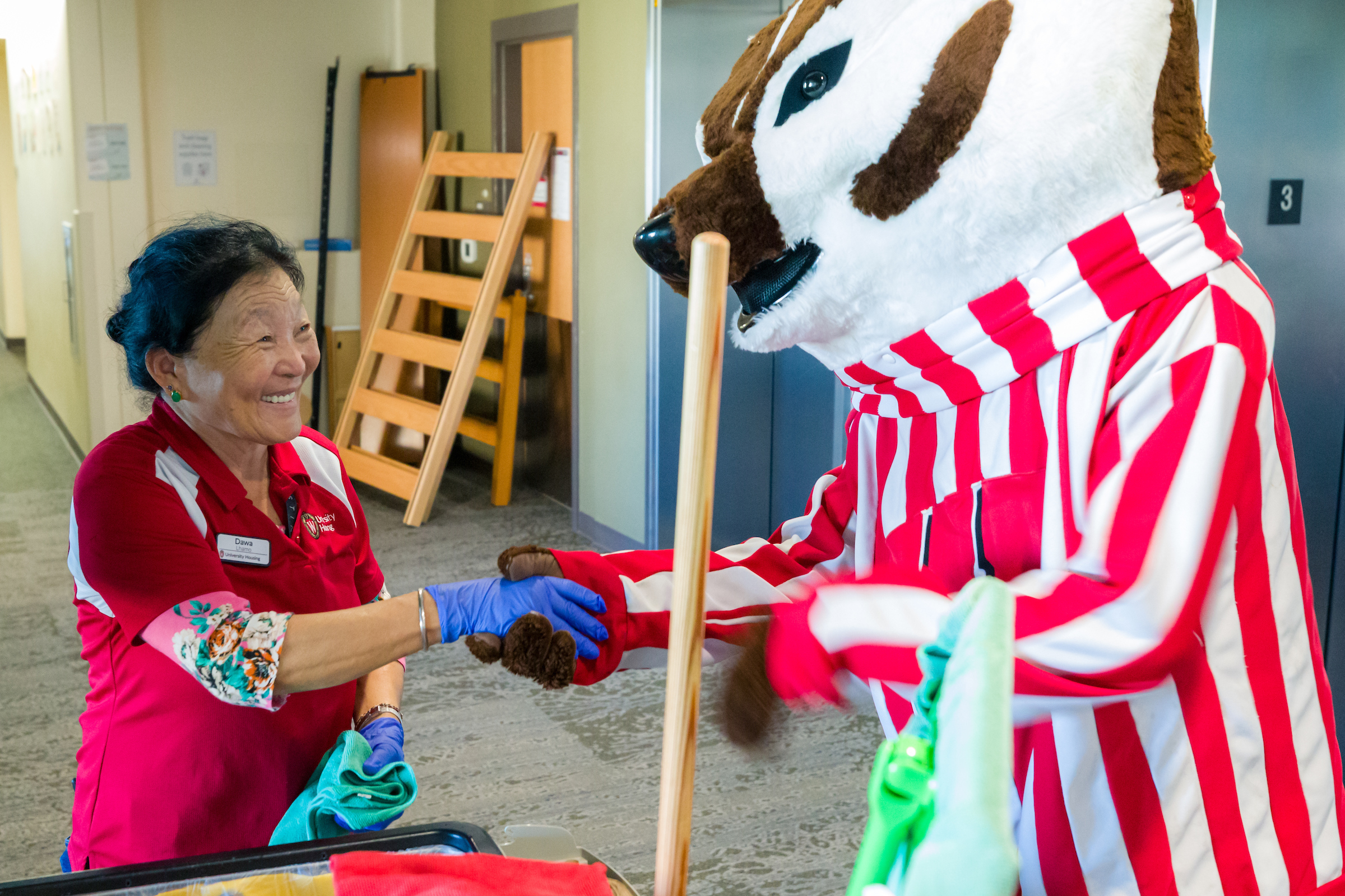 Bucky Badger interacts with a custodial staff member in Dejope Residence Hall