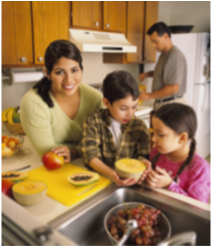 A family of four preparing healthy food together