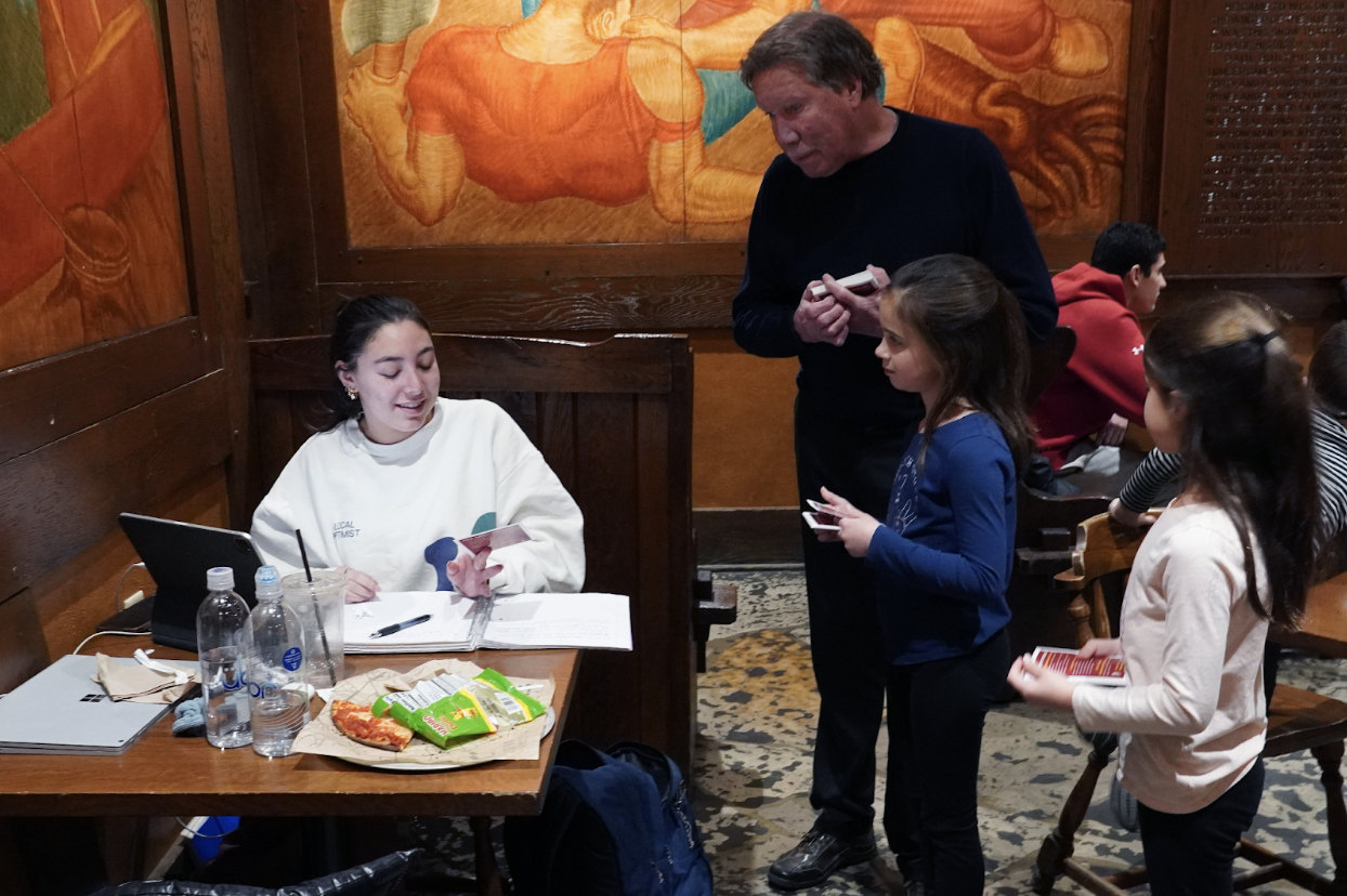 Vivian Marmor takes a break from studying to read a flyer about smoke alarms, as Tim Talen and his grandchildren, Lydia and Evelyn, look on. The Talen family marked the 15th anniversary of the death of Peter Talen by talking with students at Memorial Union and Union South to raise awareness about fire safety.