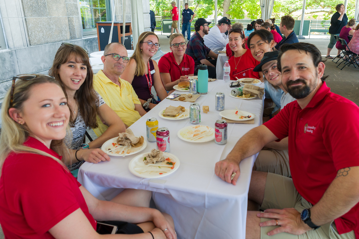 Residential Operations staff sitting at a table posing for a photo at the Housing Staff Summer BBQ